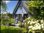 Veranda aus grauem Granit mit diversen blauen Pflanztöpfen umrandet